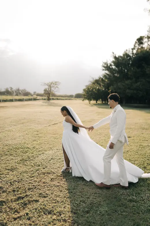 Casal caminhando pelo gramado com o Monumento Del Fiol ao fundo